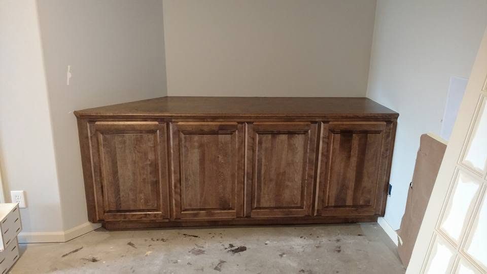 Wooden four-door cabinet with raised panel doors in a room under construction
