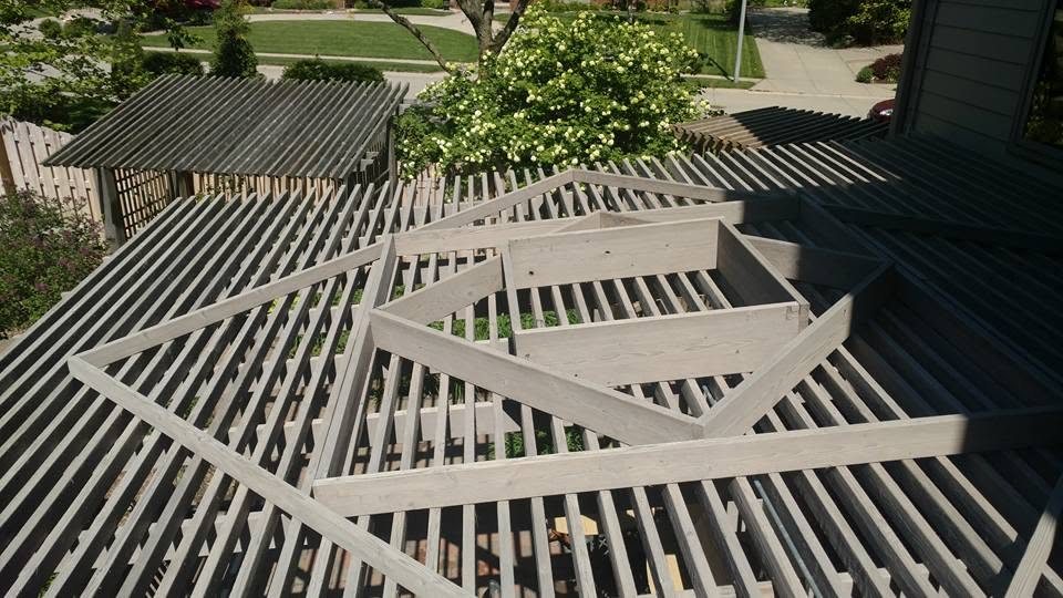 Modern pergola structures with linear slats casting shadows over residential garden area